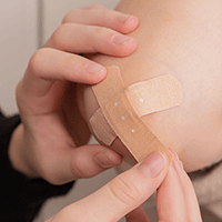 Man wrapping hand with gauze Opens in new window